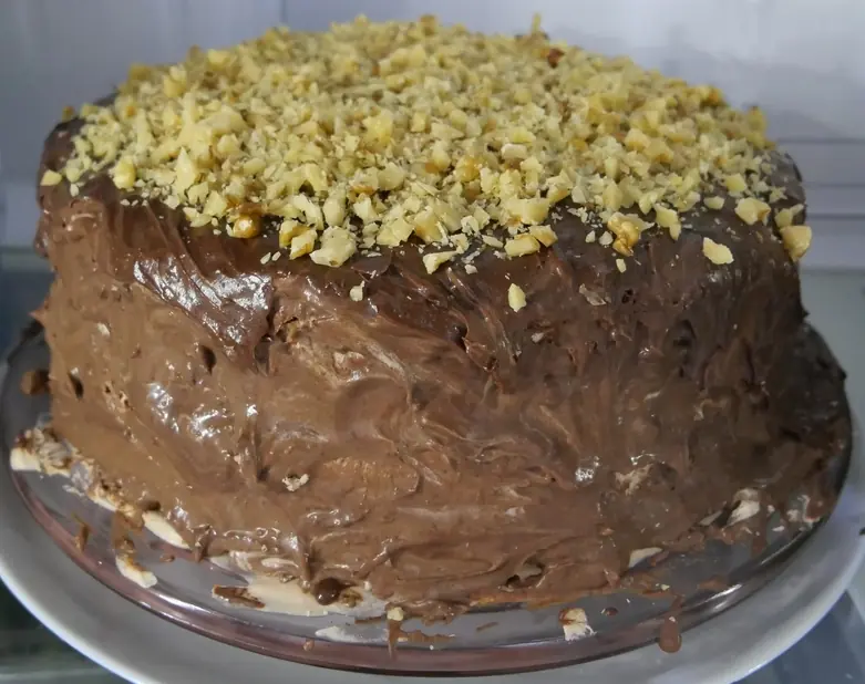 The cake topped with chopped walnuts.