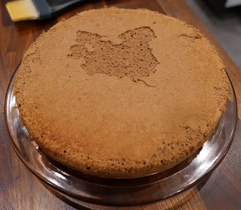 One cake layer inverted onto a cake plate.